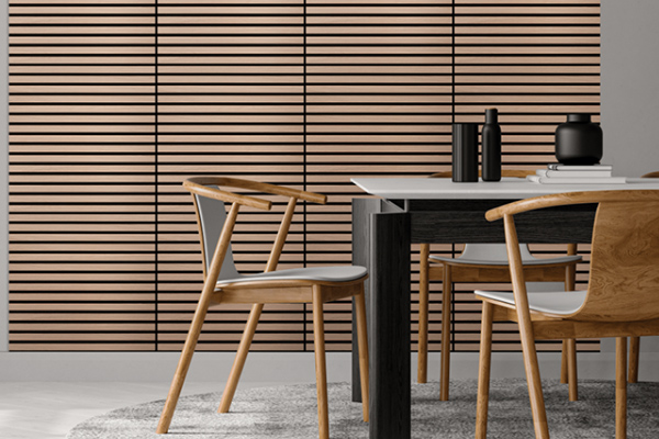 Chaises en bois clair entourent une table noire sur un tapis gris, devant un mur à lamelles horizontales.