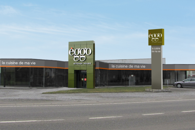 Façade d'un magasin èggo avec enseigne verte et noire, entourée de vitrines et d'un grand panneau publicitaire sur la droite.