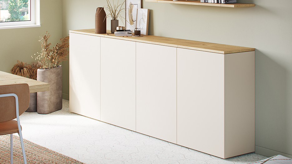 Vaisselier clair avec plateau en bois, décoré de vases et cadres, situé dans une pièce lumineuse avec sol en carrelage blanc.